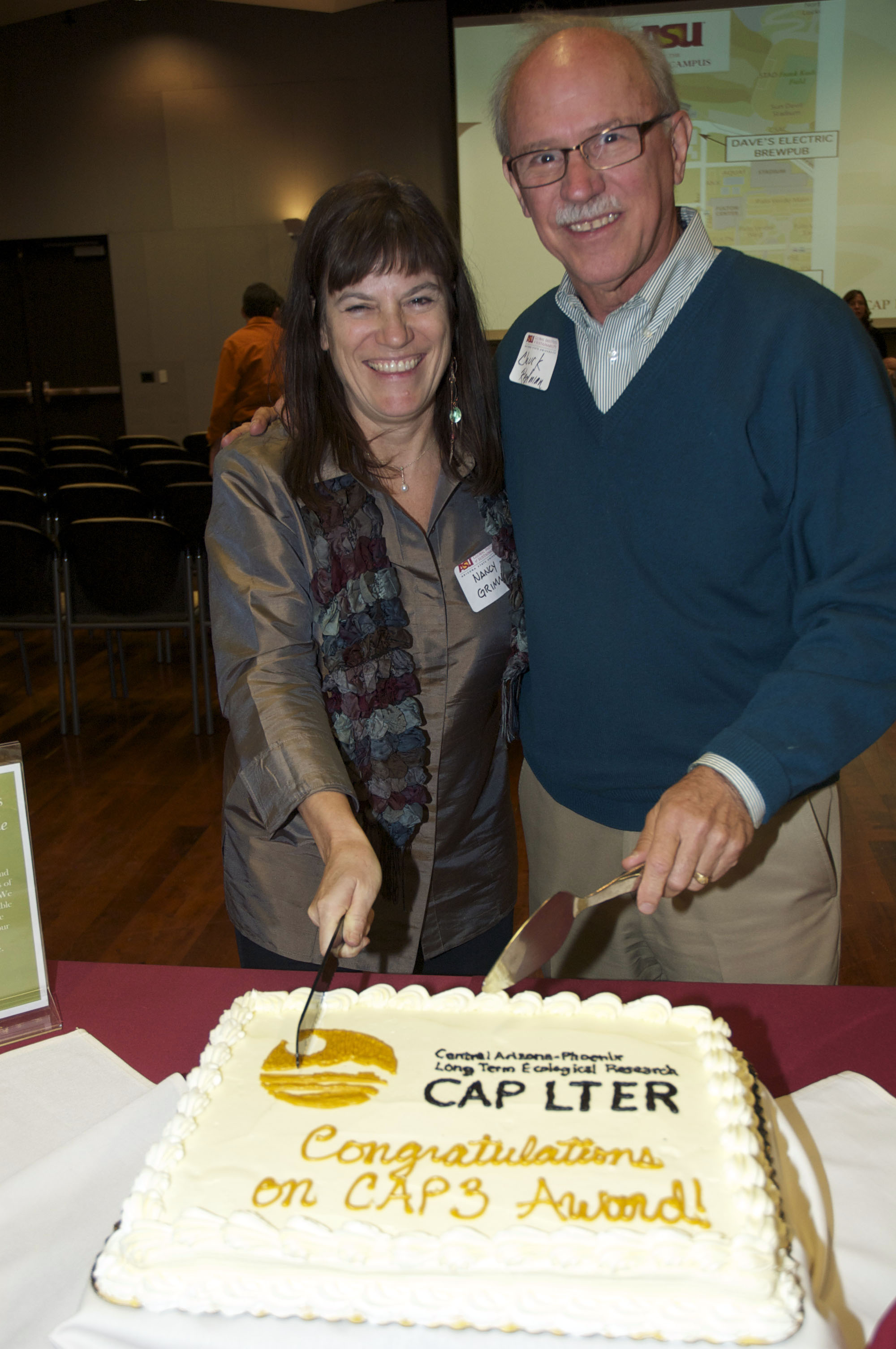 Former co-directors Nancy Grimm and Charles Redman cut a cake celebrating a new grant from NSF.