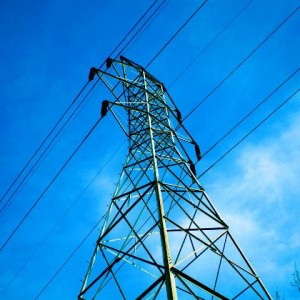 Electrical towering looming in front of a bright blue sky