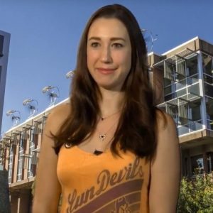 Leah Sunna sits in yellow ASU tank top in front of Wrigley Hall backdrop.