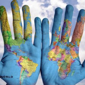 Two hands next to each other showing painted world map on palms