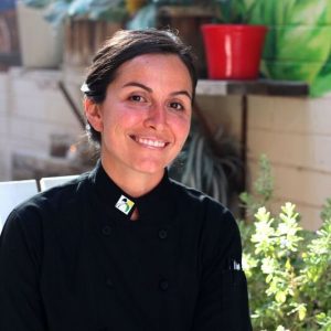 Chef Danielle Leoni wearing a chef's coat and smiling