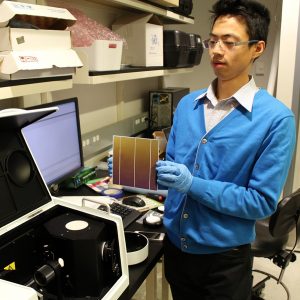 ASU Assistant Research Professor Zhengshan Yu holds up solar cell