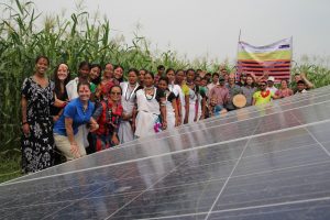 Students and Nepali community stand next to solar panels