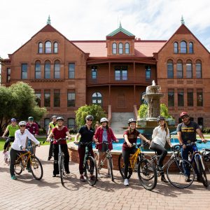 Several ASU students and staff on bikes outside of Old Main at ASU