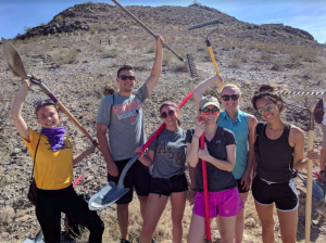 Group of ASU sustainability students picking up trash on desert hike