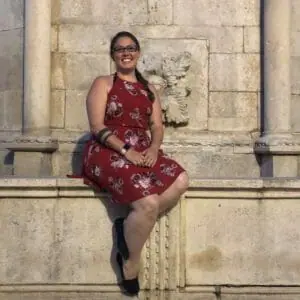 Woman smiling in dress sitting on marble building