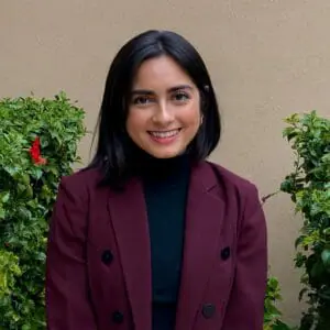 Portrait of Sukhmani Singh wearing a black turtleneck and maroon blazer