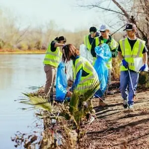 SCN EarGroup of people picking up trash along the shoreline with the Rio Reimagined project