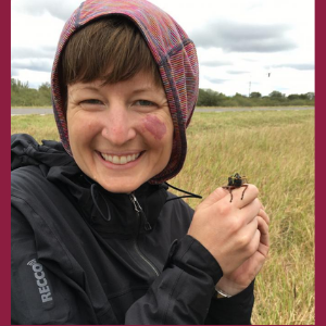 Arianne Cease in the field holding a locust.