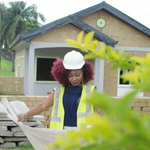 Ghislaine Tessa Ketcha wearing hard hat looking at plans