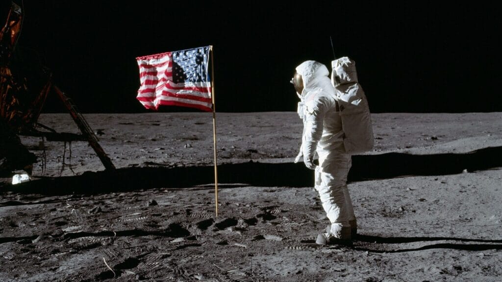 (20 July 1969) --- Astronaut Edwin E. Aldrin Jr., lunar module pilot of the first lunar landing mission, poses for a photograph beside the deployed United States flag during Apollo 11 extravehicular activity (EVA) on the lunar surface. The Lunar Module (LM) is on the left, and the footprints of the astronauts are clearly visible in the soil of the moon.