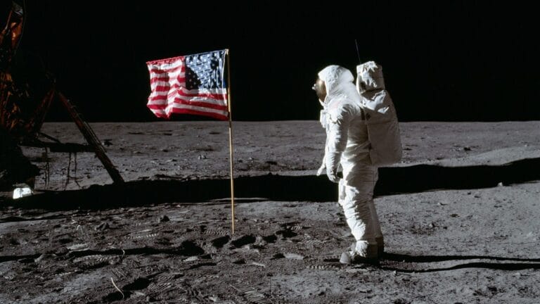 (20 July 1969) --- Astronaut Edwin E. Aldrin Jr., lunar module pilot of the first lunar landing mission, poses for a photograph beside the deployed United States flag during Apollo 11 extravehicular activity (EVA) on the lunar surface. The Lunar Module (LM) is on the left, and the footprints of the astronauts are clearly visible in the soil of the moon.