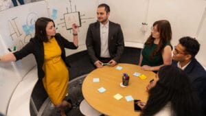 Group of people having a discussion around a table in a small meeting room.