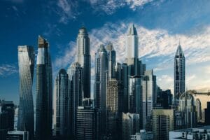 City skyline with modern skyscrapers under a blue sky with clouds.